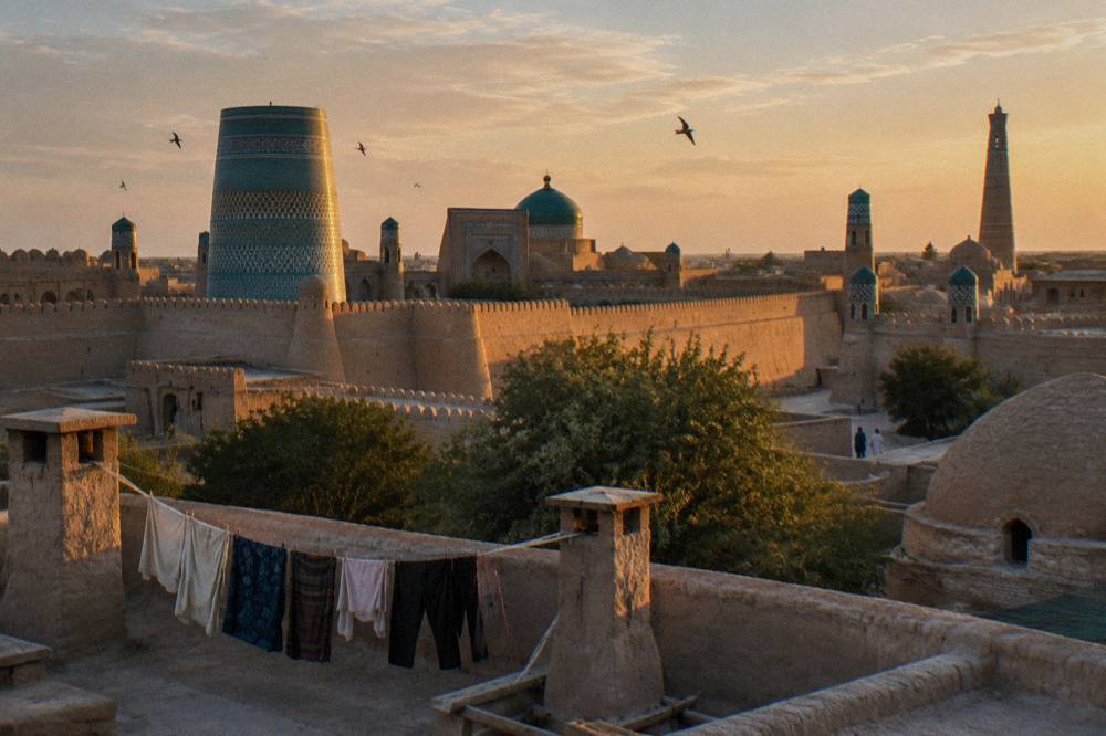 Walled inner city of Khiva with mud brick ramparts and tall minarets in late afternoon light