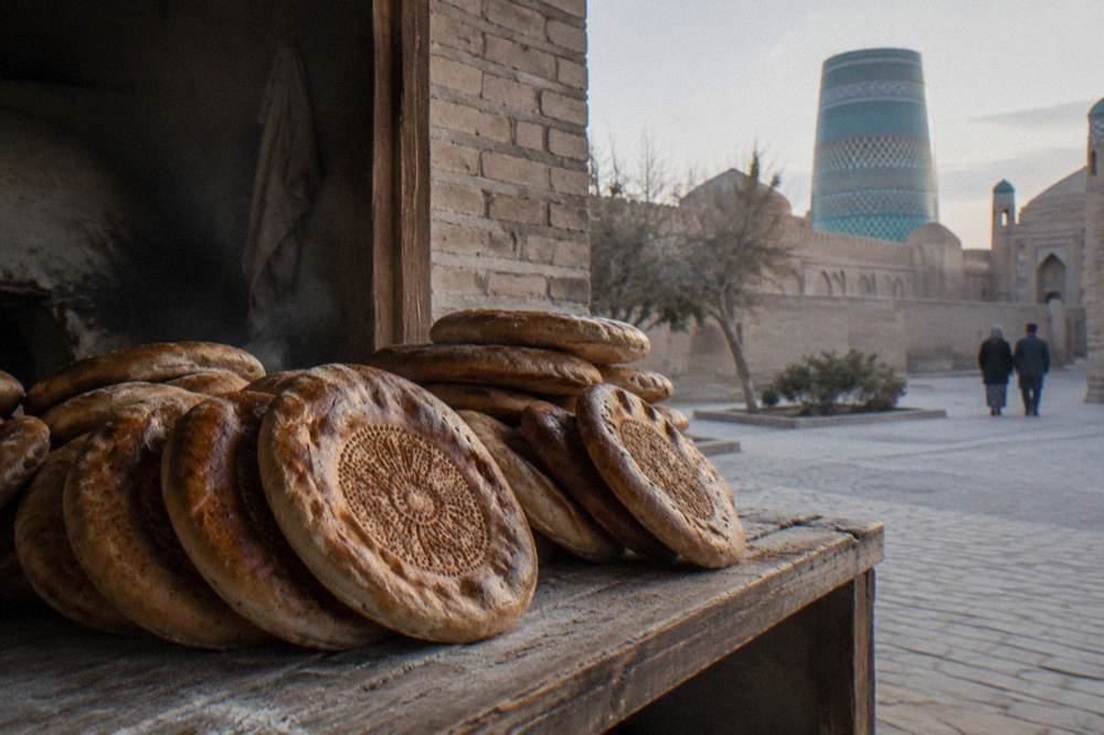 Flatbreads stamped with decorative patterns cooling in stacks at a bakery window