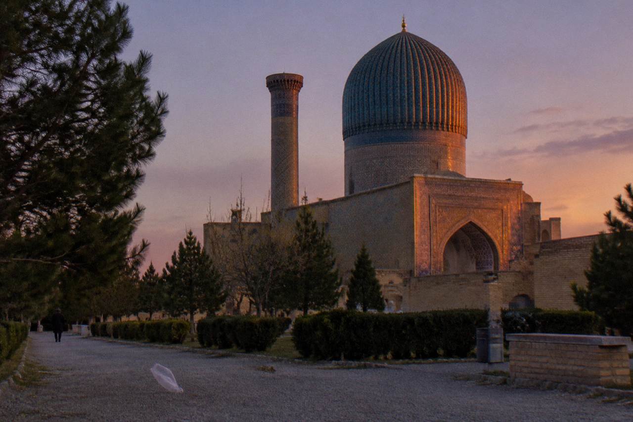A tiled facade of a medieval Silk Road city glowing under an evening sky