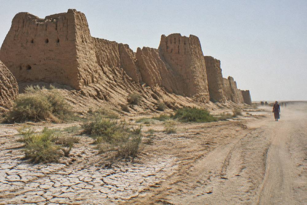 Ancient mud brick fortress walls standing in open desert under a wide sky