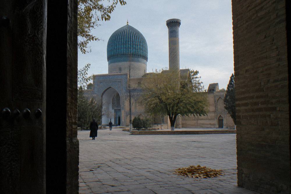 Blue tiled portal and minaret of a medieval monument in Samarkand with an empty courtyard