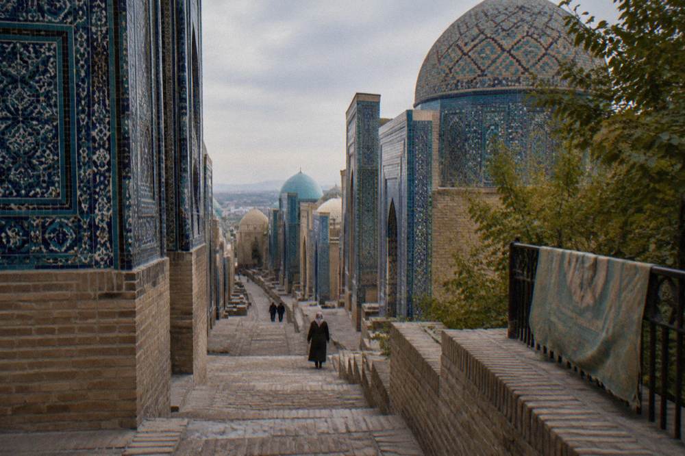 A long avenue of blue tiled tomb facades at Shah-i-Zinda receding into the distance