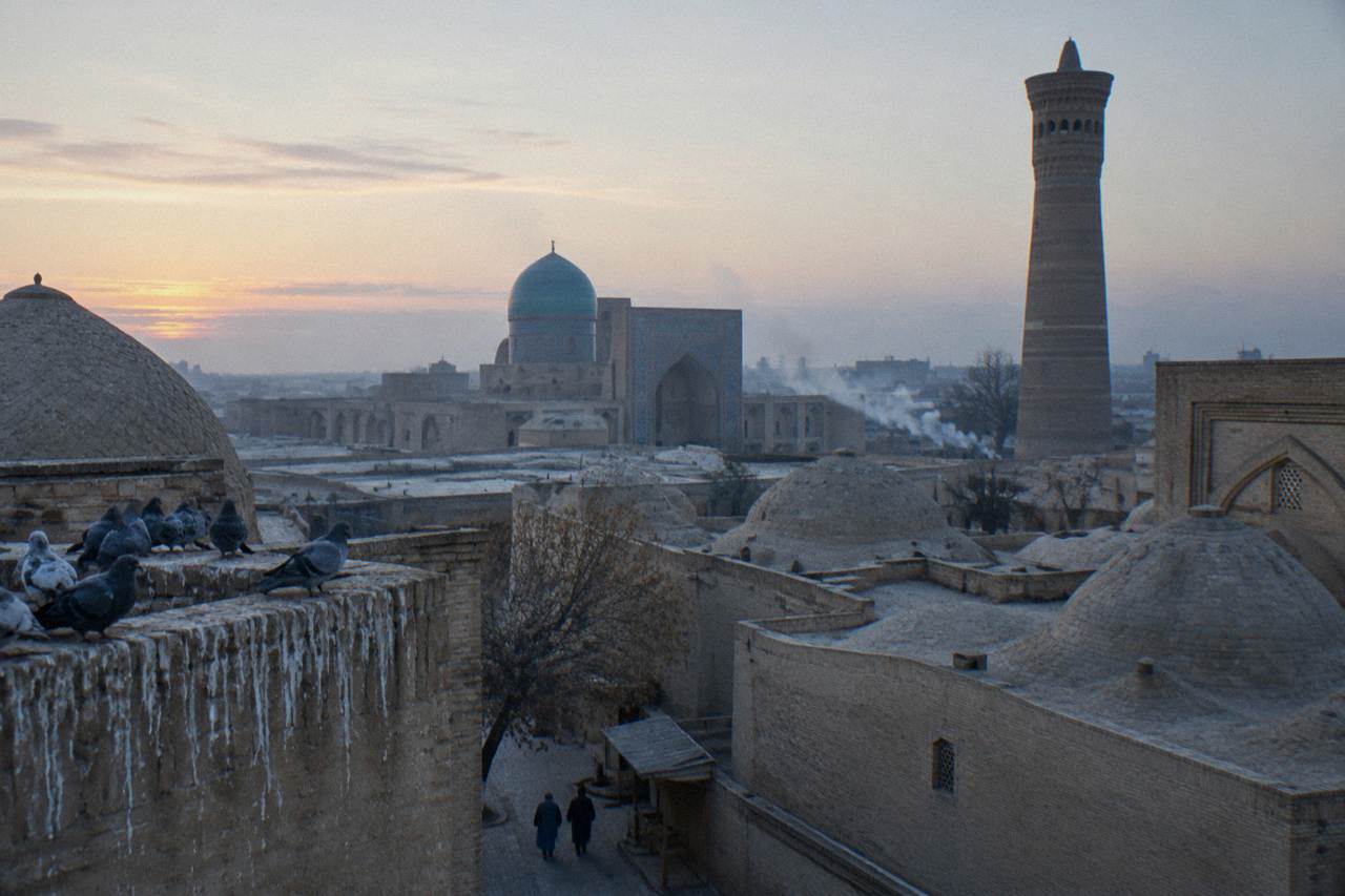 Ancient minarets and domed rooftops of Bukhara's old town under a clear sky