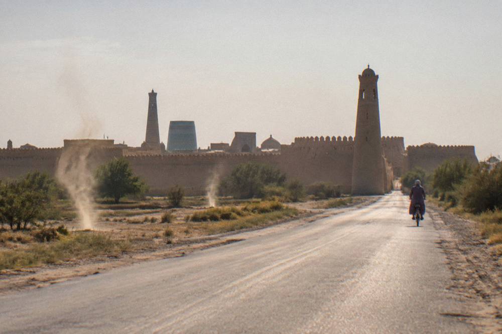 Long empty road crossing desert plains toward the walls of Khiva