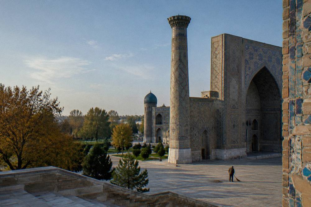 Blue tiled portal and minaret of a medieval madrasah in Samarkand under open sky