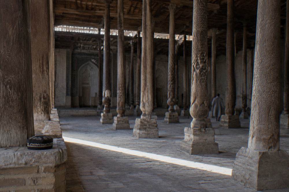 Carved wooden columns and doors on a historic building in Khiva's old town