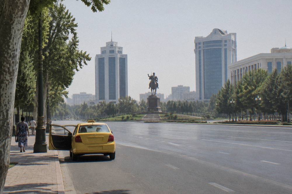 Wide tree lined avenue in central Tashkent with modern buildings along both sides