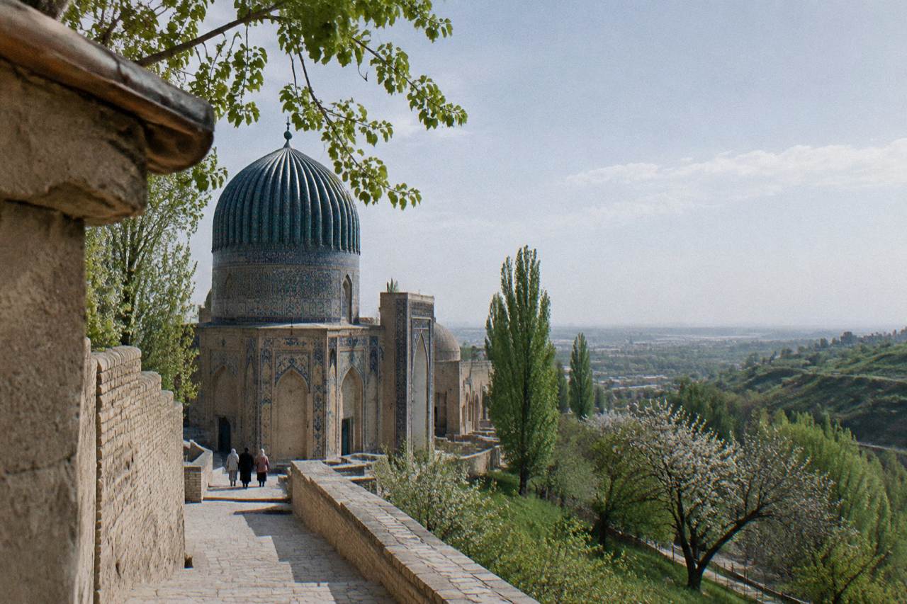 Blue-tiled dome of a Silk Road monument under a clear sky in Uzbekistan
