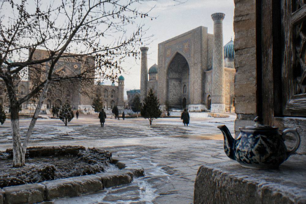 Frost-edged courtyard of an old madrasah under a pale winter sky