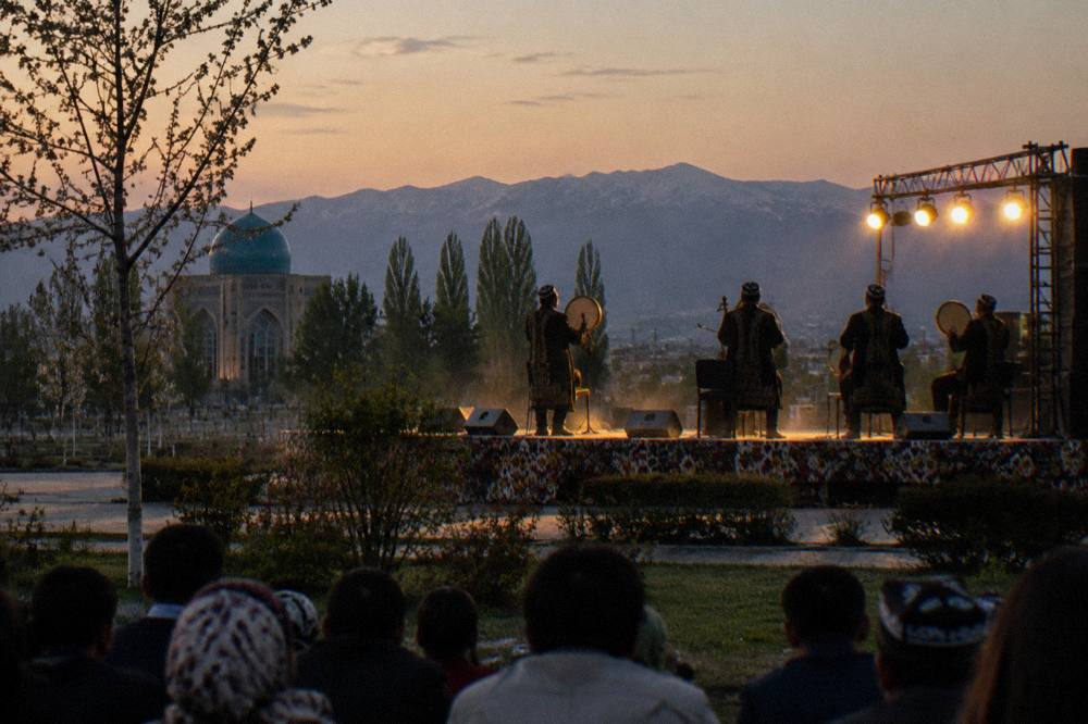 Musicians in traditional dress performing on an outdoor stage at a festival