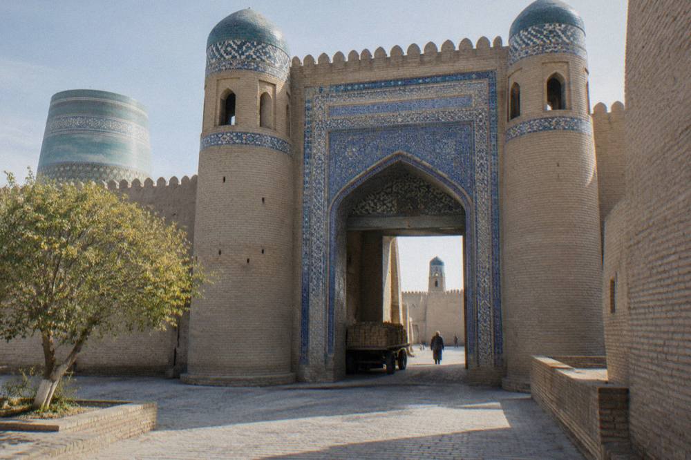 Walled fortress gateway with tiled arches in an old Central Asian city