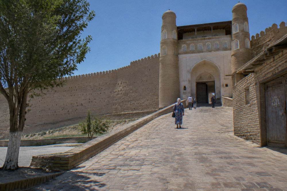 Sloping ramp leading to a fortified citadel gate under blue sky