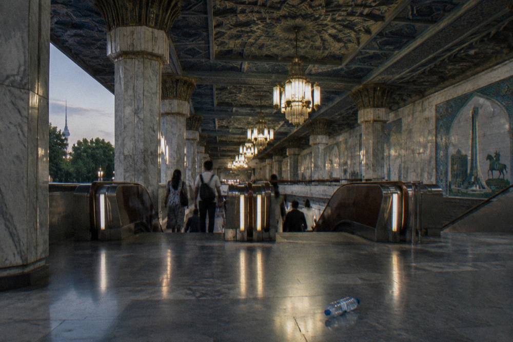 Ornate metro station hall in Tashkent with chandeliers and a patterned ceiling