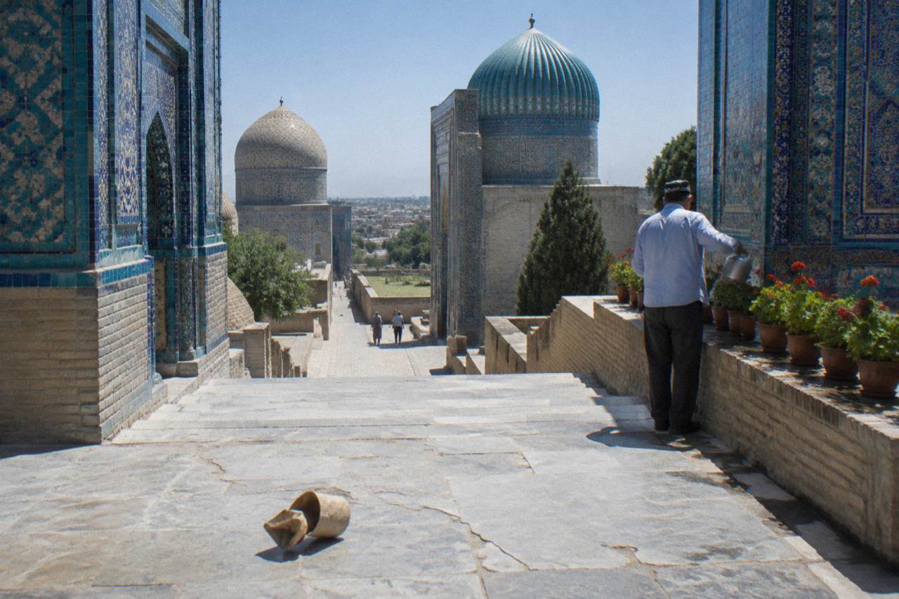 Wide view of a tiled mosque courtyard in Samarkand under a clear sky