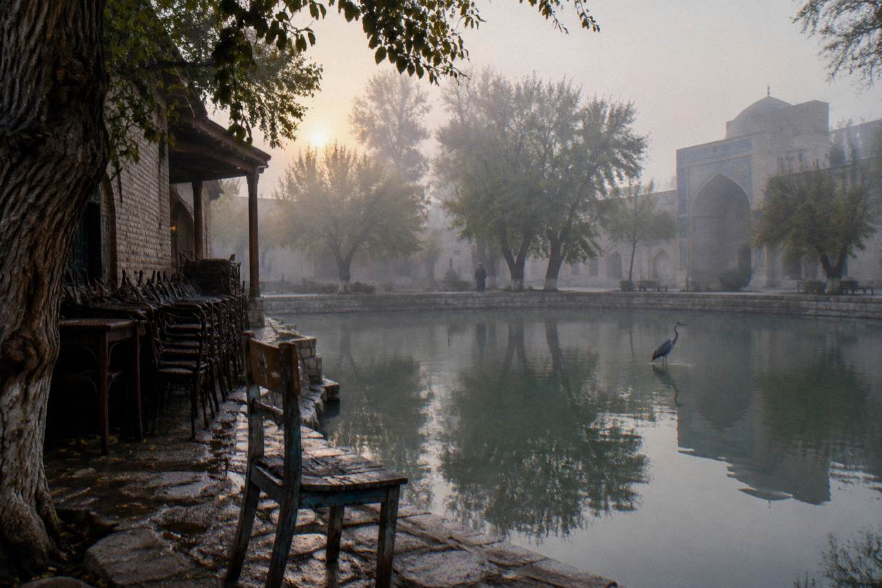 A quiet pedestrian street in a Uzbek old town with tiled facades and mulberry trees