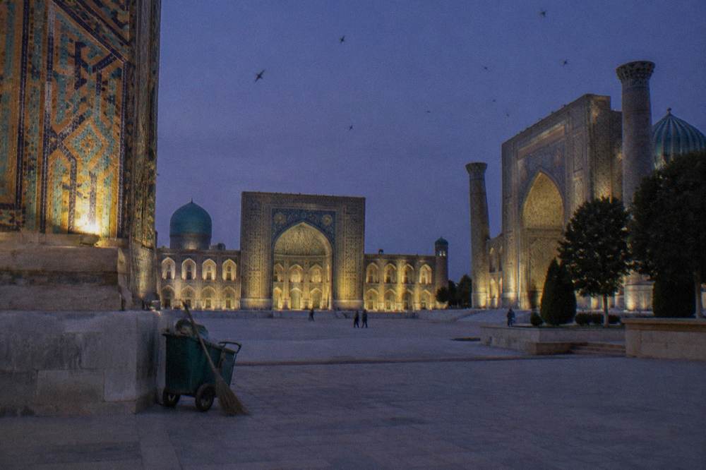 Vast tiled square with three monumental facades glowing at golden hour