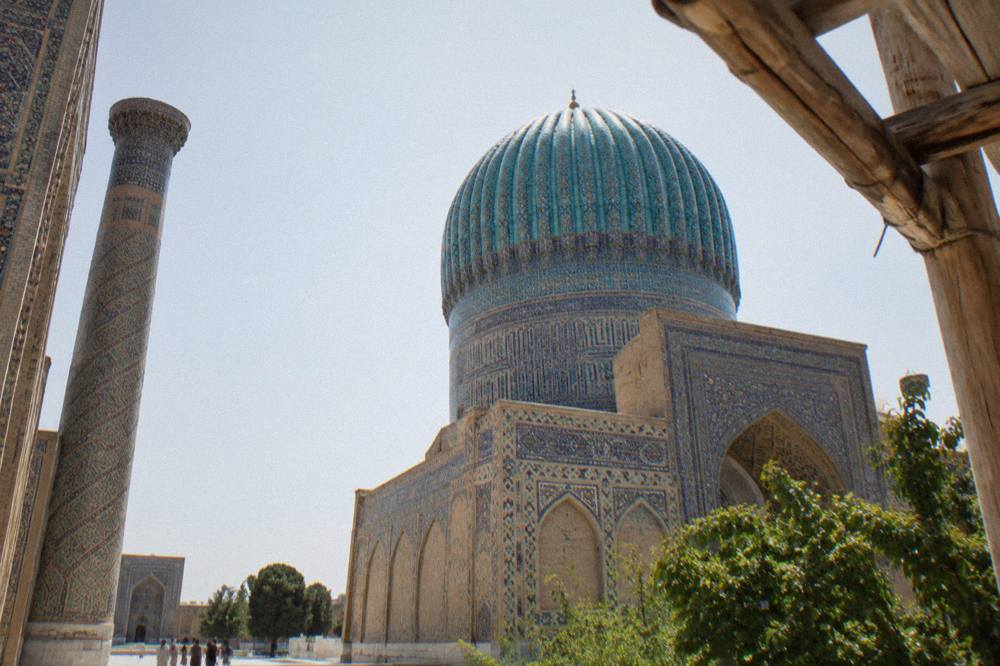Blue and turquoise tiled dome and minaret rising above the Registan square in Samarkand
