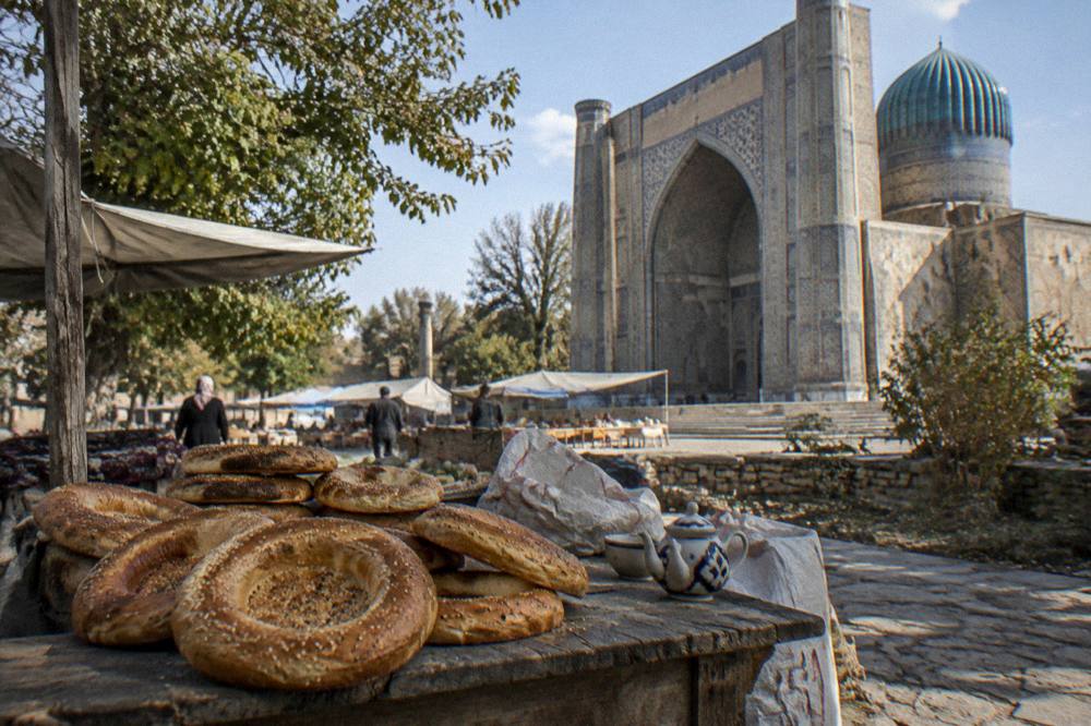 Round flatbread loaves stacked at a stall in a Samarkand bazaar