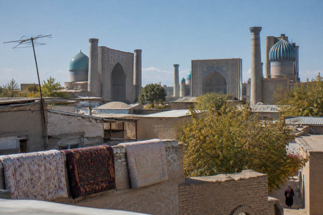 Blue tiled domes and minarets of a medieval Silk Road city under a clear sky
