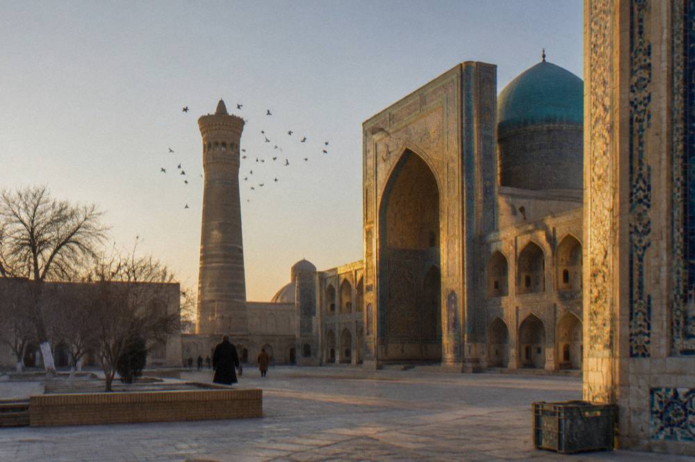 Ornate tiled facade of a medieval mosque complex glowing in late afternoon light