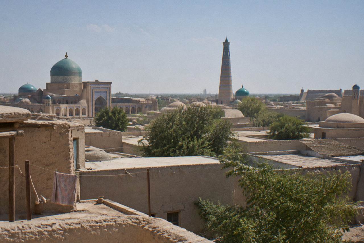 Blue tiled domes and minarets of a historic Silk Road city under a clear sky