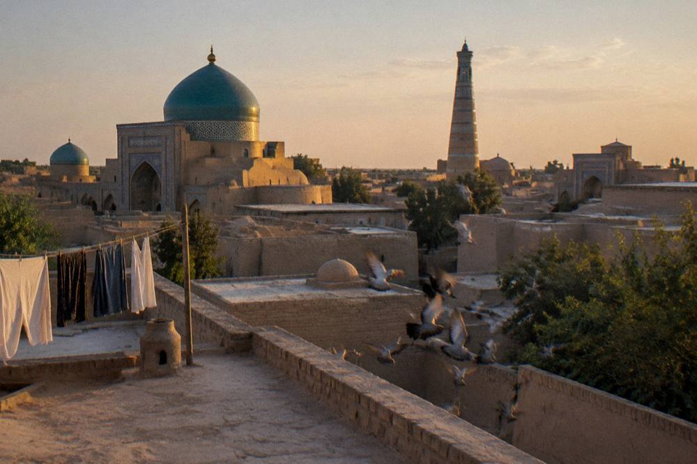 Blue tiled dome and minaret of an ancient Silk Road city glowing in late afternoon light