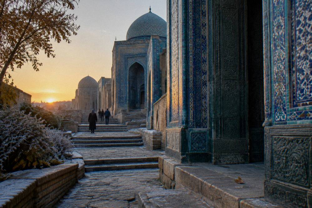 Ancient necropolis street of tiled mausoleums leading uphill toward a domed portal