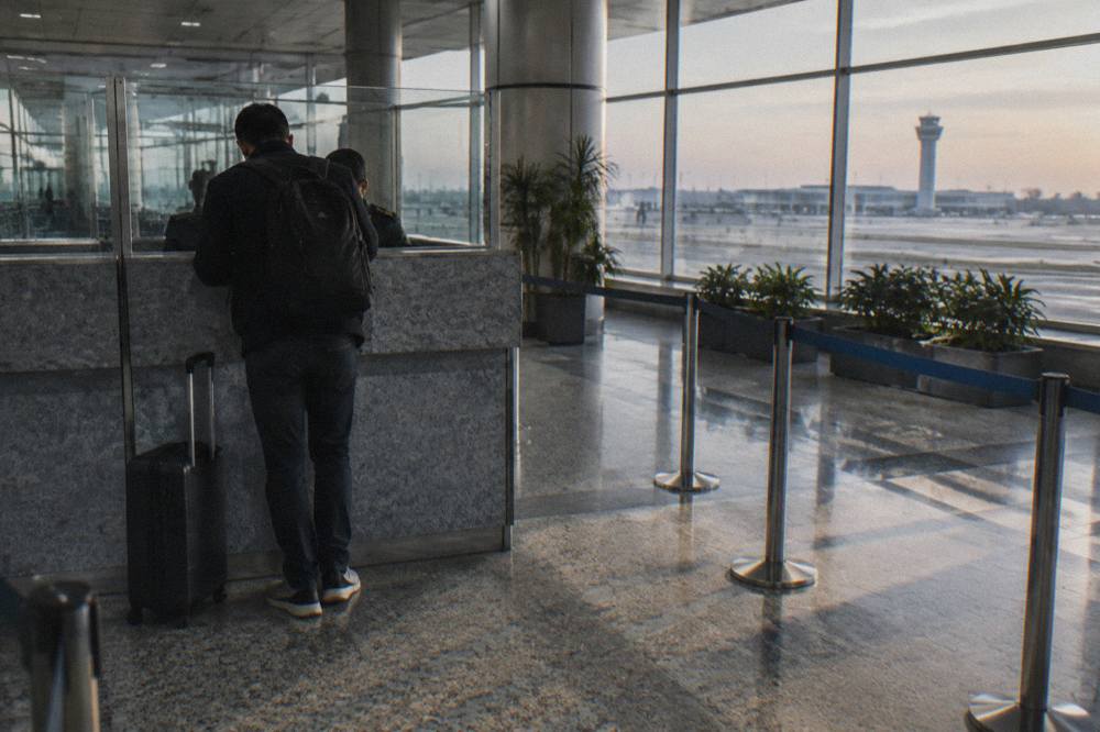 Traveler handing a passport to a border officer at a Uzbekistan arrivals counter