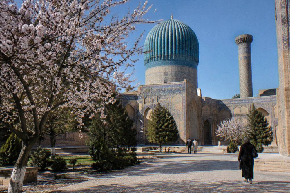 Blue-tiled dome of a medieval monument in Samarkand under a clear sky
