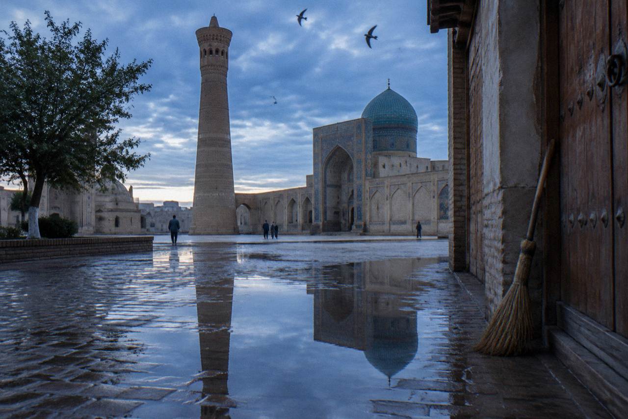 Blue-tiled dome and minaret of a historic Silk Road city under a clear sky